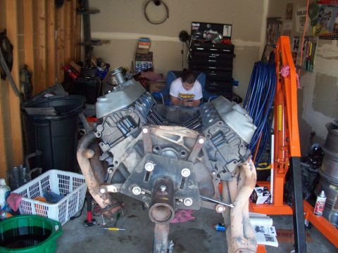 1985 Ford Bronco - A V8 engine is mounted on an engine stand in a garage setting.