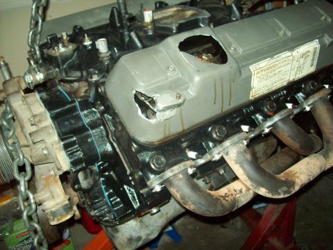 1985 Ford Bronco - Engine assembly with visible damage to the valve cover and exhaust components.