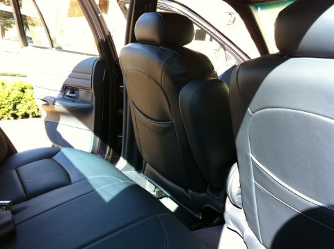 1999 Ford Crown Victoria - Interior view of car seats and door panel, showing the back seat and part of the driver's side door.