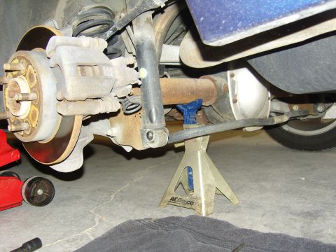 2007 Ford Mustang - The rear axle and suspension of a vehicle are supported by jack stands for maintenance.