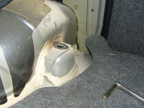 2007 Ford Mustang - The interior of a car trunk shows exposed metal and grey carpeting, with a socket wrench visible.