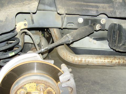 2007 Ford Mustang - Close-up view of a rear suspension shock absorber and brake rotor assembly on a vehicle.