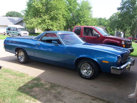 1973 Ford Ranchero - A blue 1973 Ford Ranchero is parked in a driveway with a red truck behind it.