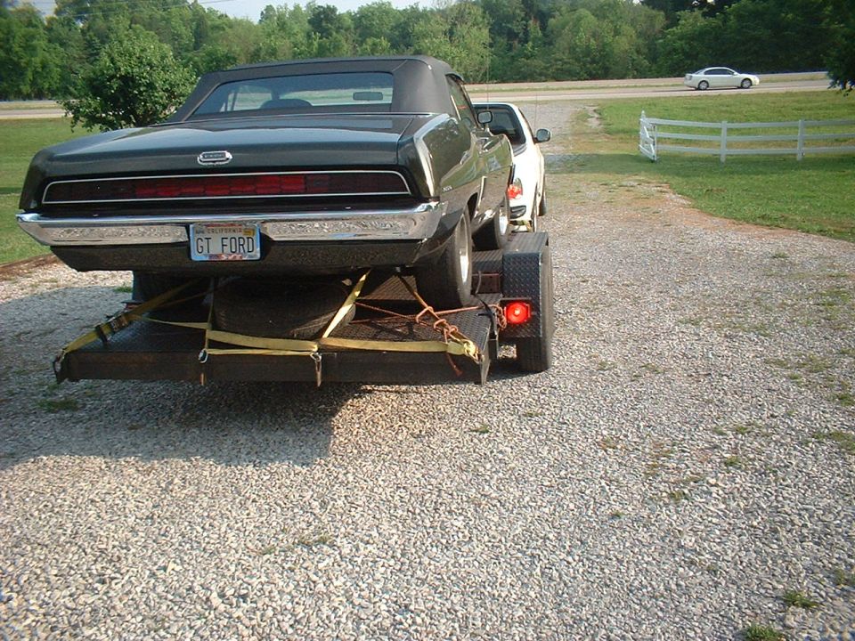Black 1970 Ford Torino convertible on a trailer, rear view. License plate reads GT FORD