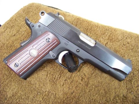 1995 Mercury Grand Marquis - A handgun is shown from a side angle on a textured surface.