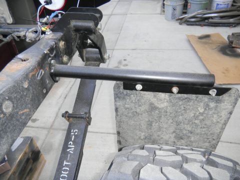 1997 Ford Ranger - Close-up view of a truck's leaf spring and mud flap assembly, showing part markings and mounting hardware.
