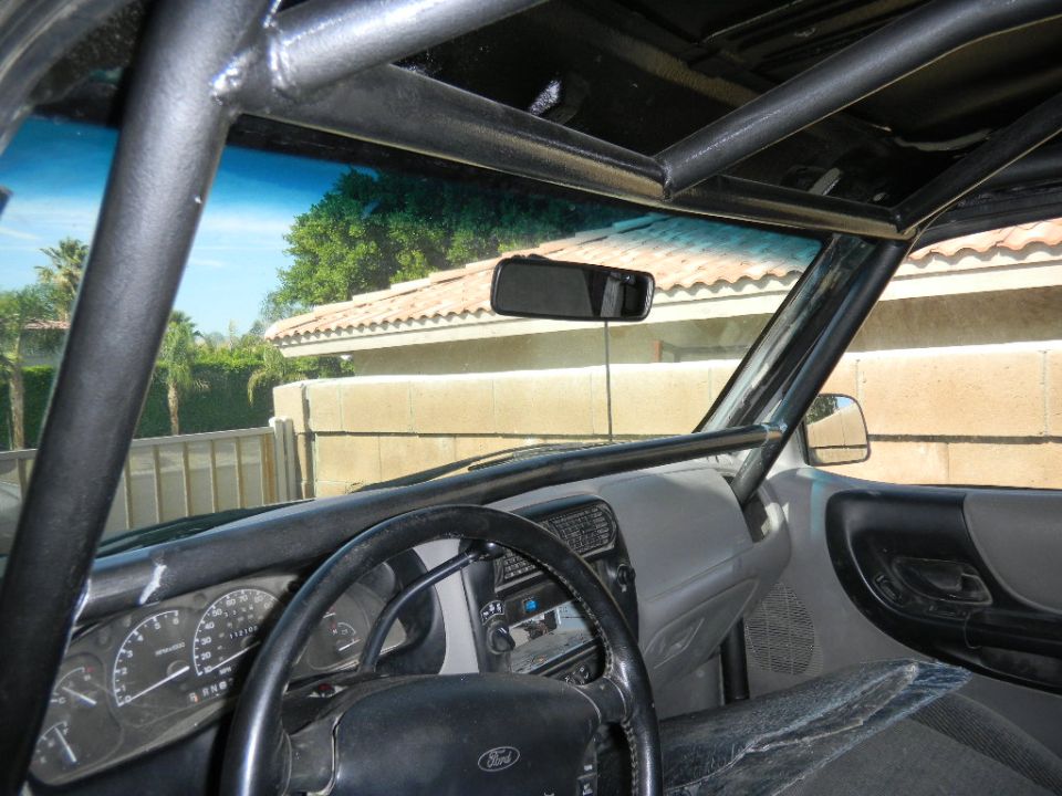 1997 Ford Ranger interior with roll cage, aftermarket stereo, and modified dashboard