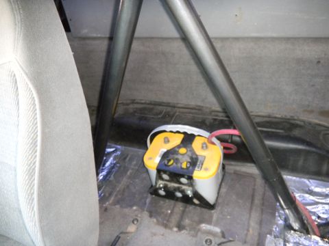 1997 Ford Ranger - A yellow Optima battery is visible inside a vehicle, mounted behind the seat and near a roll cage.