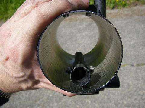 1990 Ford Bronco - Close-up of a mass air flow sensor housing held by a hand, revealing its internal components.