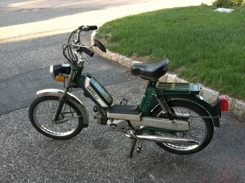 1981 Garelli Rally Sport - A green Garelli moped is parked on a paved surface next to a grassy area.