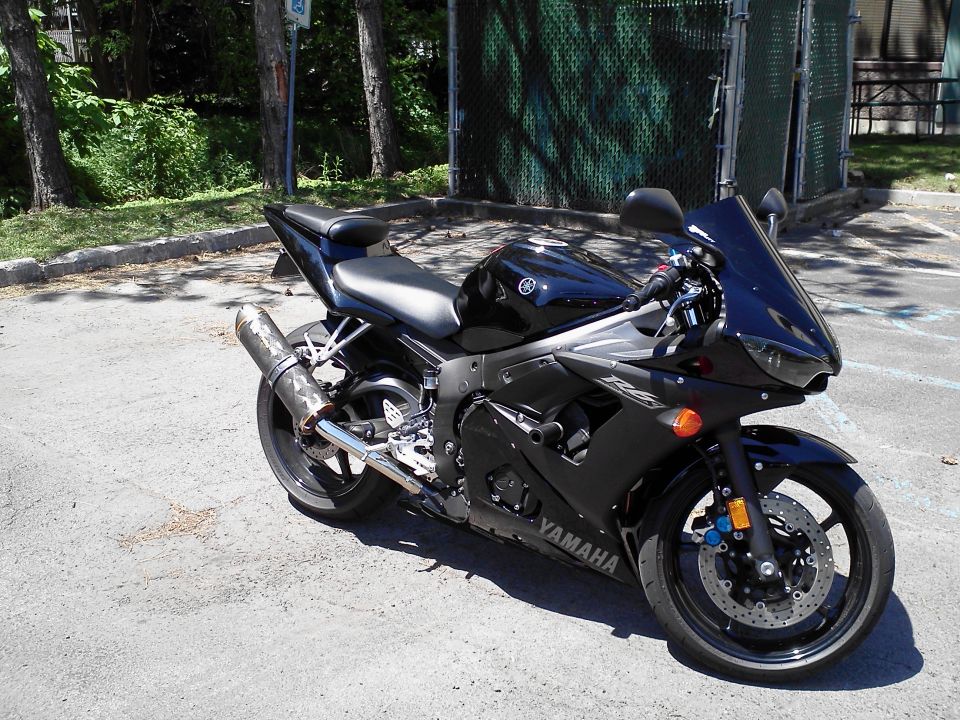 Black Yamaha sportbike motorcycle parked on asphalt. Visible text includes 'YAMAHA' and 'R6'