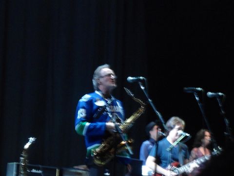 1989 Ford Bronco - A band plays live on stage, with a saxophonist in the foreground wearing a blue jersey.