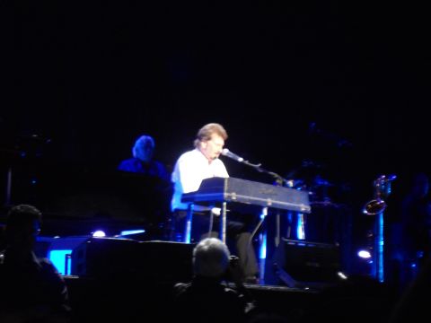 1989 Ford Bronco - A keyboardist performs on stage during a concert, illuminated by blue stage lighting.