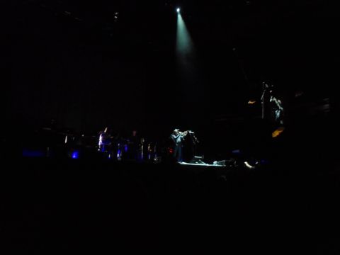 1989 Ford Bronco - A musician performs on stage with a spotlight illuminating them and their band.