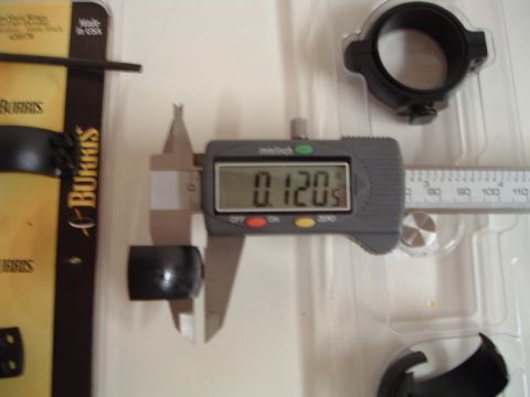 1995 Mercury Grand Marquis - A digital caliper measures a black cylindrical part to 0.120 inches, with Burris packaging visible.