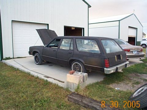 1982 Mercury Zephyr - Station wagon with hood open, parked outside a garage. Another vehicle is visible in the background.