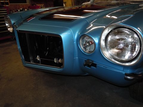 1972 Chevrolet Camaro - The front of a blue car is shown, missing its grille and with one headlight exposed.