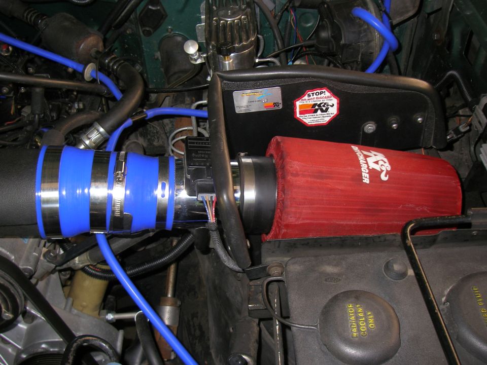 Red K&N cone filter and polished intake tube with blue silicone couplers in engine bay