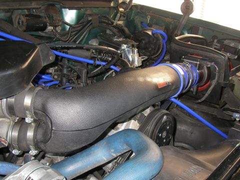 1990 Ford Bronco - Close-up view of an engine bay, highlighting an aftermarket air intake system and various hoses.