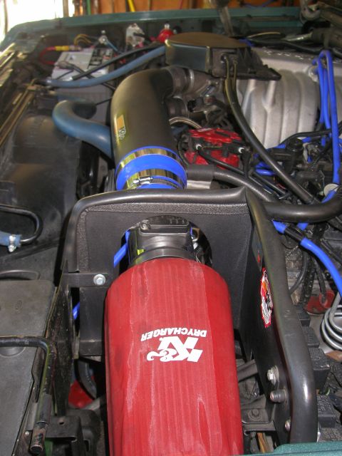 1990 Ford Bronco - Close-up of a red K&N DRYCHARGER air filter installed in an engine bay.