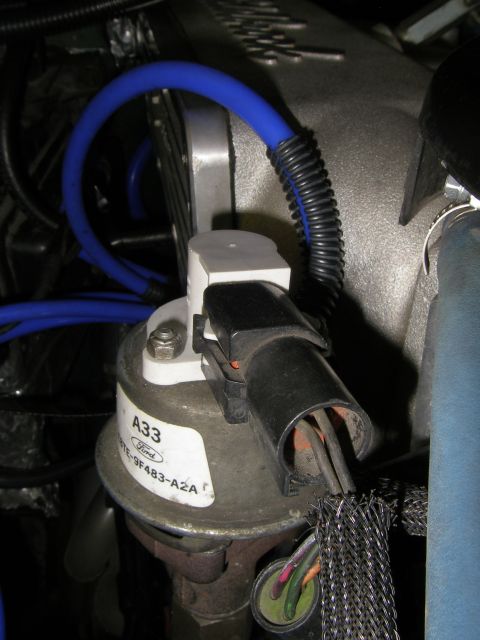 1990 Ford Bronco - Engine component with Ford branding and part number E9TE-9F483-A2A, connected to blue vacuum hoses.