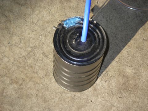 1990 Ford Bronco - A vacuum canister with a blue hose connected to its top, resting on a concrete surface.