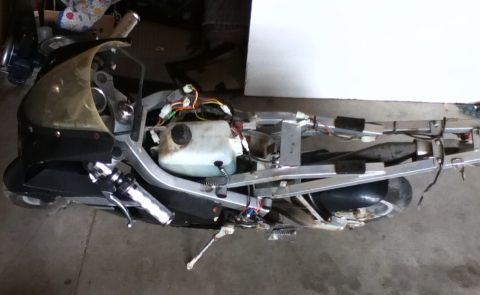 2006 Ford E350 - A disassembled motorcycle frame shows the engine, fuel tank, and electrical wiring.