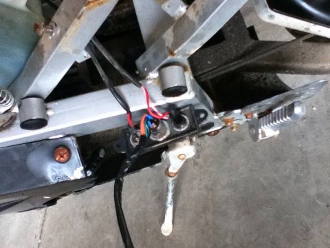 2006 Ford E350 - Motorcycle kickstand and wiring detail, showing electrical connections and metal frame components.