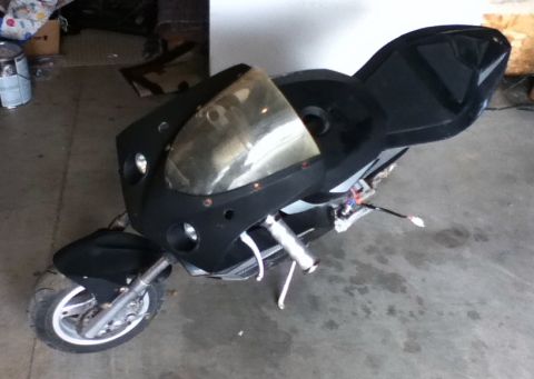 2006 Ford E350 - This is a sport motorcycle with a tinted windshield and exposed wiring, parked indoors on a concrete floor.