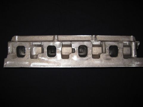 1972 Ford Ranchero - Close-up of an engine intake manifold, likely for a V6 or inline-6 engine, against a black background.