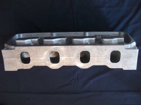 1972 Ford Ranchero - An aluminum intake manifold is shown against a dark background. The part features four intake ports visible on each side.