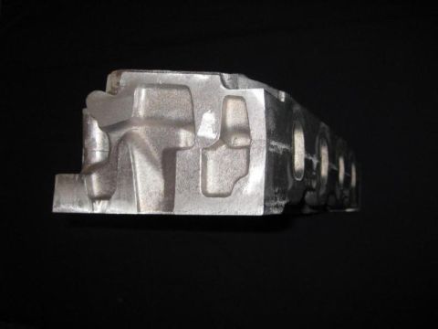 1972 Ford Ranchero - An engine cylinder head is shown against a black background, with visible ports and bolt holes.