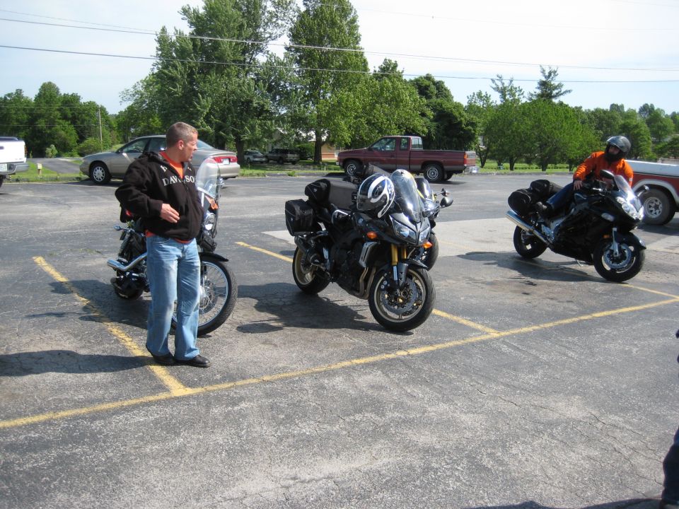 Black sport touring motorcycle parked in a lot with two other motorcycles