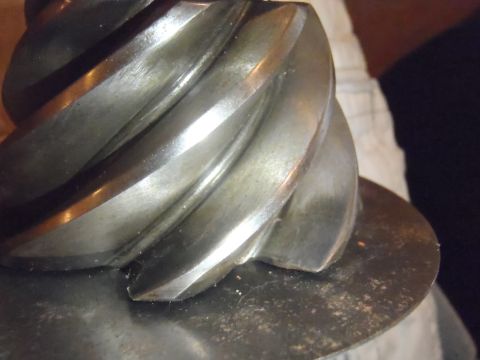1990 Ford Bronco - Close-up of a metal worm gear, showing its helical teeth and a flat mounting surface.