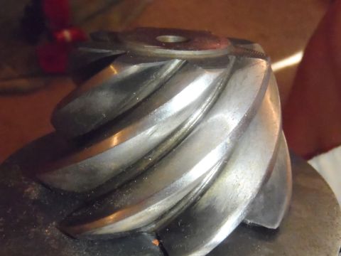 1990 Ford Bronco - A close-up view of a metal differential gear, showing its intricate spiral teeth.