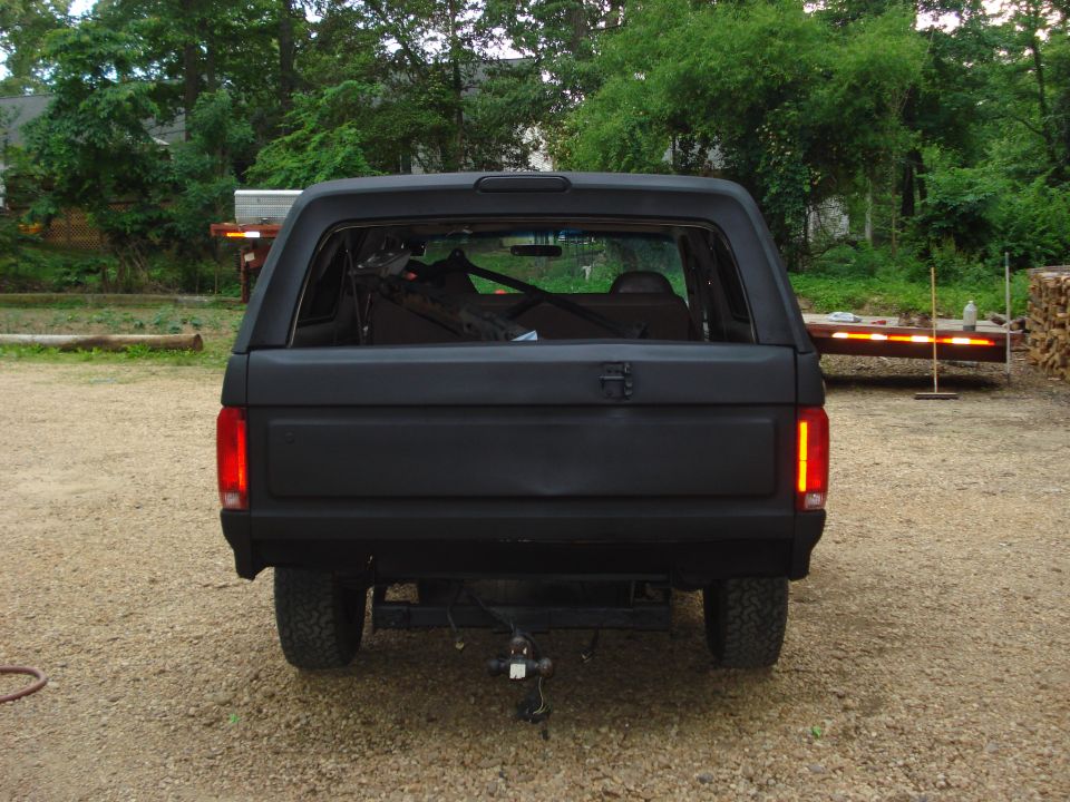 Black SUV rear view, matte finish, trailer hitch, aftermarket taillights