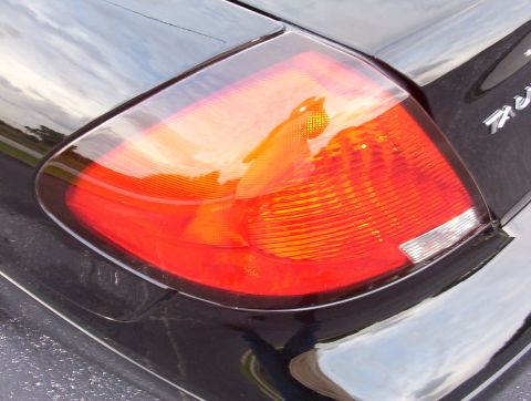 2003 Ford Taurus - Taillight assembly on a vehicle, with 'SUPERMOTORS' branding visible.