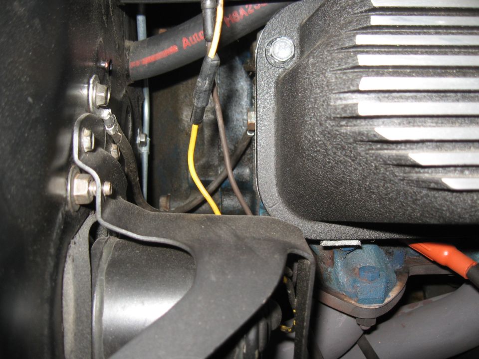 Close-up of engine bay with hoses, wires, and valve cover visible. Supermotors.net logo in corner