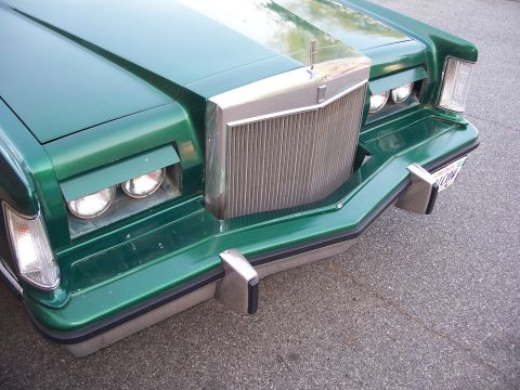 1971 Ford Ranchero - Front view of a green car stacked headlights and a prominent vertical chrome grille.