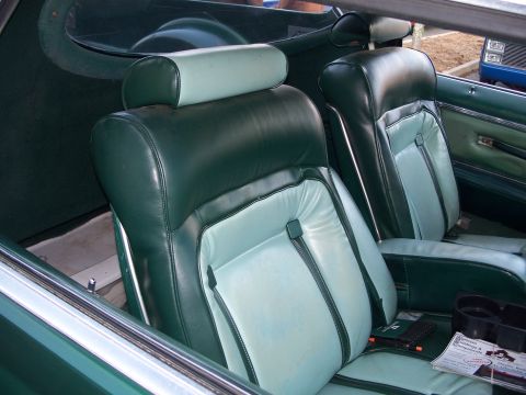 1971 Ford Ranchero - The interior of a car features two-tone green and light blue seats with headrests.