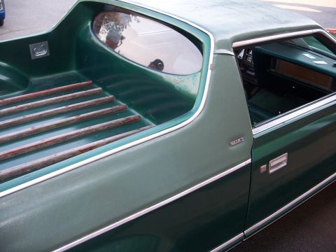 1971 Ford Ranchero - A green pickup truck with a wooden slat bed and a 'VILLAGER' badge on the side.