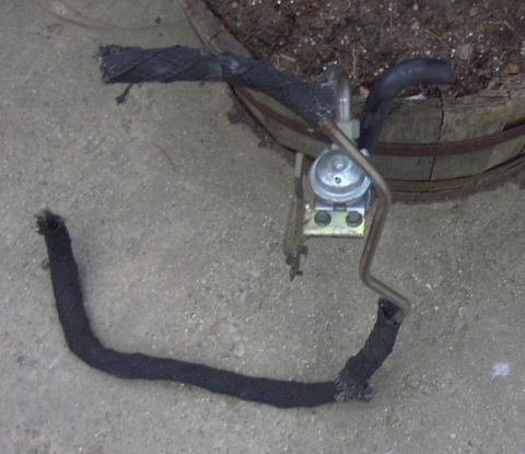 1997 Ford Taurus - Fuel filter and hoses, possibly for a Ford Taurus, shown on a concrete surface.