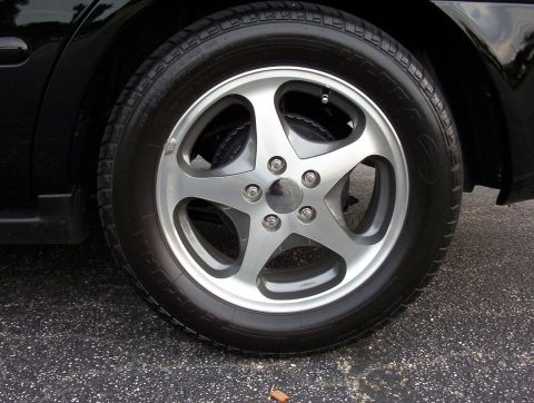 2003 Ford Taurus - A close-up view of a car's wheel and tire on asphalt, with a watermark for Supermotors.net visible.