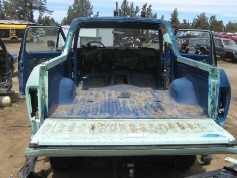 1978 Ford Bronco - The rear view of a 1978 Ford Bronco shows its open doors and empty bed.