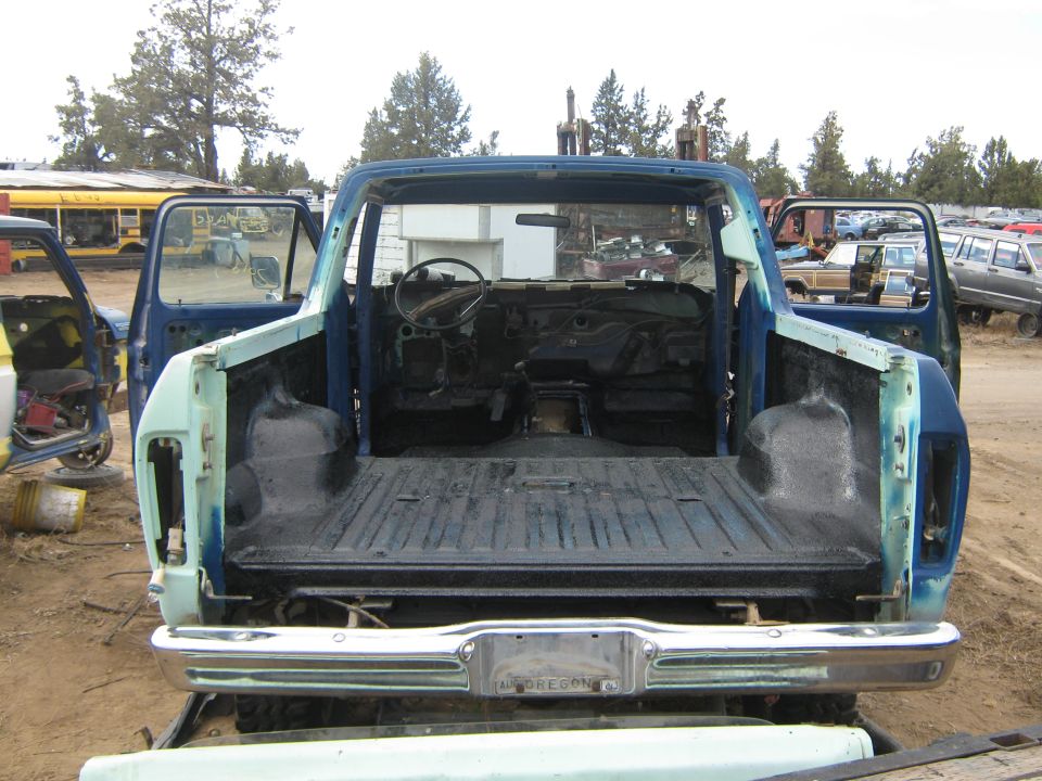 Blue 1978 Ford Bronco with open doors and removed roof, showing interior and bed