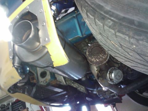 1995 Ford Probe - This photo shows the undercarriage of a vehicle, focusing on the exhaust system and a tire.