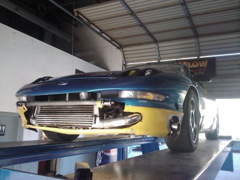 1995 Ford Probe - This modified Ford Probe is on a lift with its front bumper removed, revealing a large intercooler.