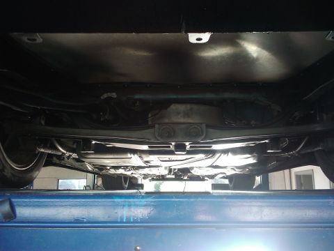 1995 Ford Probe - The underside of a vehicle is viewed from below while it is elevated on a lift.