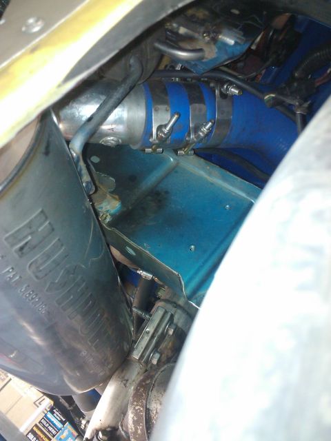 1995 Ford Probe - Engine bay components including a blue hose and exhaust pipe with visible text.