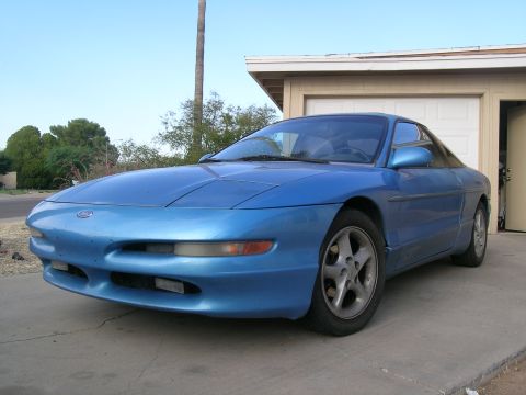 1995 Ford Probe - A blue coupe, likely a 1993 model, is parked in front of a residential garage.